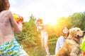 Young girl playing squirt guns with her brother on pier during summer Royalty Free Stock Photo