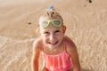 Young girl playing, swiming and splashing in fresh sea water. Smilling blonde girl in swimsuit with and swimming goggles Royalty Free Stock Photo