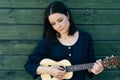 A young girl is playing ukulele