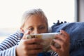 Young Girl  Playing Video Games On Mobile Phone Sitting On Sofa At Home Royalty Free Stock Photo