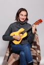 A young girl plays on a ukulele. Inside. Royalty Free Stock Photo