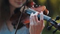 A young girl plays the violin in the city park. Royalty Free Stock Photo