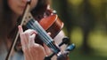 A young girl plays the violin in the city park. Royalty Free Stock Photo