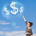 Young girl pointing at dollar sign clouds on blue sky Royalty Free Stock Photo