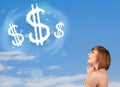 Young girl pointing at dollar sign clouds on blue sky Royalty Free Stock Photo