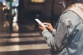 Young girl pointing finger on screen smartphone on background glow bokeh light in night atmospheric christmas city Royalty Free Stock Photo