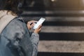 Young girl pointing finger on screen smartphone on background glow bokeh light in night atmospheric christmas city Royalty Free Stock Photo