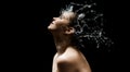 Young girl portrait and splash water in her face. beautiful female model on black background.