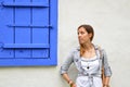 Young girl posing by the blue window shutters Royalty Free Stock Photo