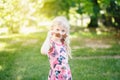 Young girl posing in fancy pink pentagonal shaped sunglasses outdoors. Cute serious pensive stylish Caucasian child with long Royalty Free Stock Photo