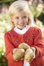 Young girl posing with potatoes in garden Royalty Free Stock Photo