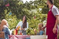 A young girl pouring orange juice into a cup and a man in a burg Royalty Free Stock Photo