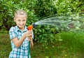 Young girl pours water from hose Royalty Free Stock Photo
