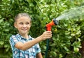Young girl pours water from hose Royalty Free Stock Photo