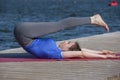 Young girl practices yoga on the shore of the lake, the concept of enjoying privacy and concentration, sunlight