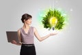 Young girl presenting idea light bulb with green tree Royalty Free Stock Photo