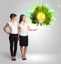 Young girl presenting idea light bulb with green tree Royalty Free Stock Photo