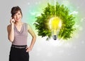 Young girl presenting idea light bulb with green tree Royalty Free Stock Photo