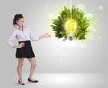 Young girl presenting idea light bulb with green tree Royalty Free Stock Photo