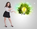 Young girl presenting idea light bulb with green tree Royalty Free Stock Photo