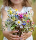 A young girl presents a bouquet of wildflowers