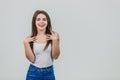 The young girl is pretty Caucasian standing in a white background. Putting hands on her hair.