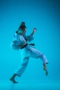 Young girl professional judoist isolated on blue studio background in neon light. Healthy lifestyle, sport concept. Royalty Free Stock Photo