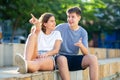 Girl prompts the boy, pointing with his hand at something