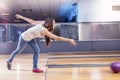 Young girl pulls the ball on the bowling alley