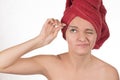 Young girl pulls out her eyebrows with tweezers metal on a white Royalty Free Stock Photo