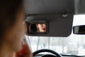 A young girl puts make-up in the car.