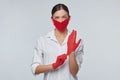 Young girl puts on red gloves and a face mask. Concept for preventing coronavirus covid 19 Royalty Free Stock Photo