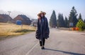 Young girl in a raincoat in the morning at dawn against a background of fog and mountains Royalty Free Stock Photo