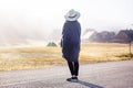 Young girl in a raincoat in the morning at dawn against a background of fog and mountains Royalty Free Stock Photo