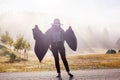 Young girl in a raincoat in the morning at dawn against a background of fog and mountains Royalty Free Stock Photo