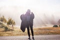 Young girl in a raincoat in the morning at dawn against a background of fog and mountains Royalty Free Stock Photo