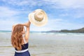 Young girl raise a hat in the sky on the beach. Summer vocation island Royalty Free Stock Photo