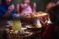 A young girl raises her hands in prayer as she prepares for her iftar meal during the holy month of Ramadan, embodying Royalty Free Stock Photo