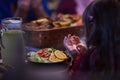 A young girl raises her hands in prayer as she prepares for her iftar meal during the holy month of Ramadan, embodying Royalty Free Stock Photo