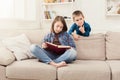 Young girl reading book for her brother Royalty Free Stock Photo