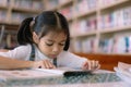 A young girl is reading a book in a library Royalty Free Stock Photo