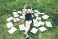 Young girl reading a book while lying in the grass. A girl among the books in the summer garden Royalty Free Stock Photo