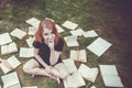 Young girl reading a book while lying in the grass. A girl among the books in the summer garden Royalty Free Stock Photo