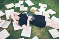 Young girl reading a book while lying in the grass. A girl among the books in the summer garden Royalty Free Stock Photo