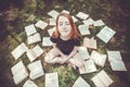Young girl reading a book while lying in the grass. A girl among the books in the summer garden Royalty Free Stock Photo