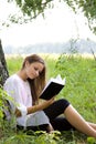 Young girl reading book in park Royalty Free Stock Photo