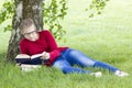 Young girl reading book in park Royalty Free Stock Photo