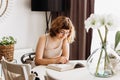 Young girl reading book at the table in dining room. Apartment living Royalty Free Stock Photo