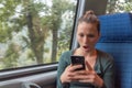 Amazed woman checking smartphone in the street after receiving a shocking news on a train journey Royalty Free Stock Photo