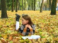 Young girl reads a book in the autumn park Royalty Free Stock Photo